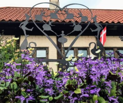 Hans Christian Andersen Park with purple flowers and Dutch architecture.