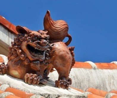 Bronze lion on top of a red tiled roof.