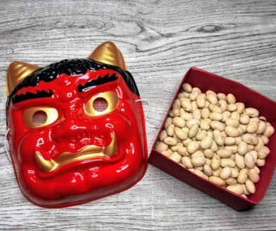 Red monster mask with horns. A box full of beans.